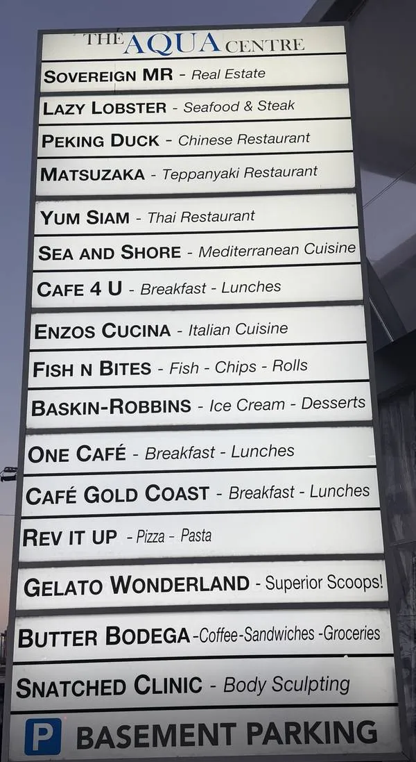 The Aqua Centre pylon sign listing tenants, with Basement Parking at the bottom